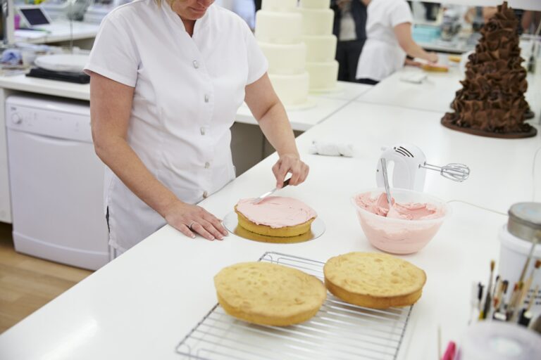 woman-in-bakery-decorating-cake-with-icing-768x512