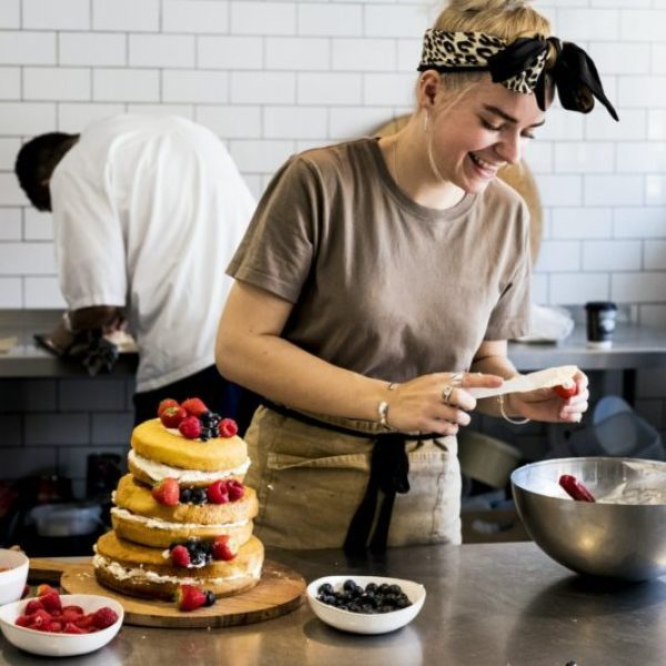 a-cook-working-in-a-commercial-kitchen-assembling-a-layered-sponge-cake-with-fresh-fruit--e1665052754551-pvt7fg4sbpi333kyx5r5yo25ej5xge93c3i5bsp4z4 (1)